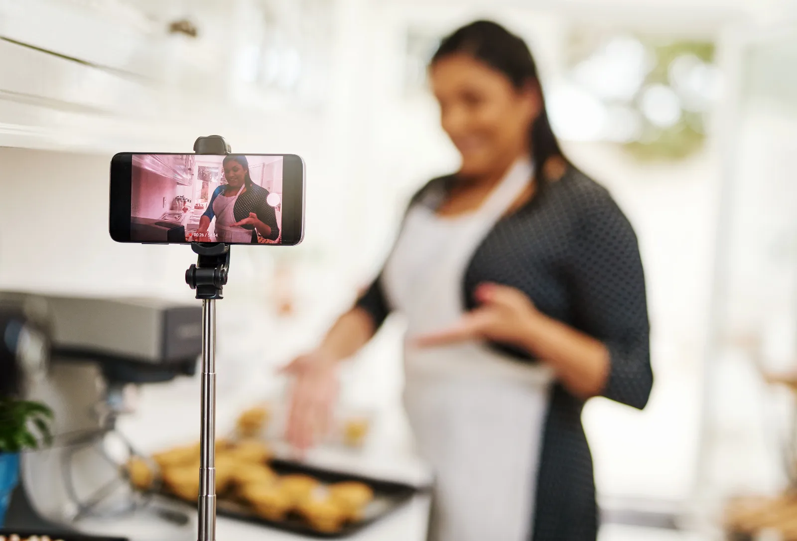 Reels para empresas: dona de boutique gravando vídeo curto com smartphone e ring light na loja