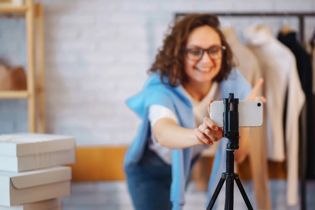 Reels para empresas: empresária gravando vídeo curto com smartphone dentro da loja
