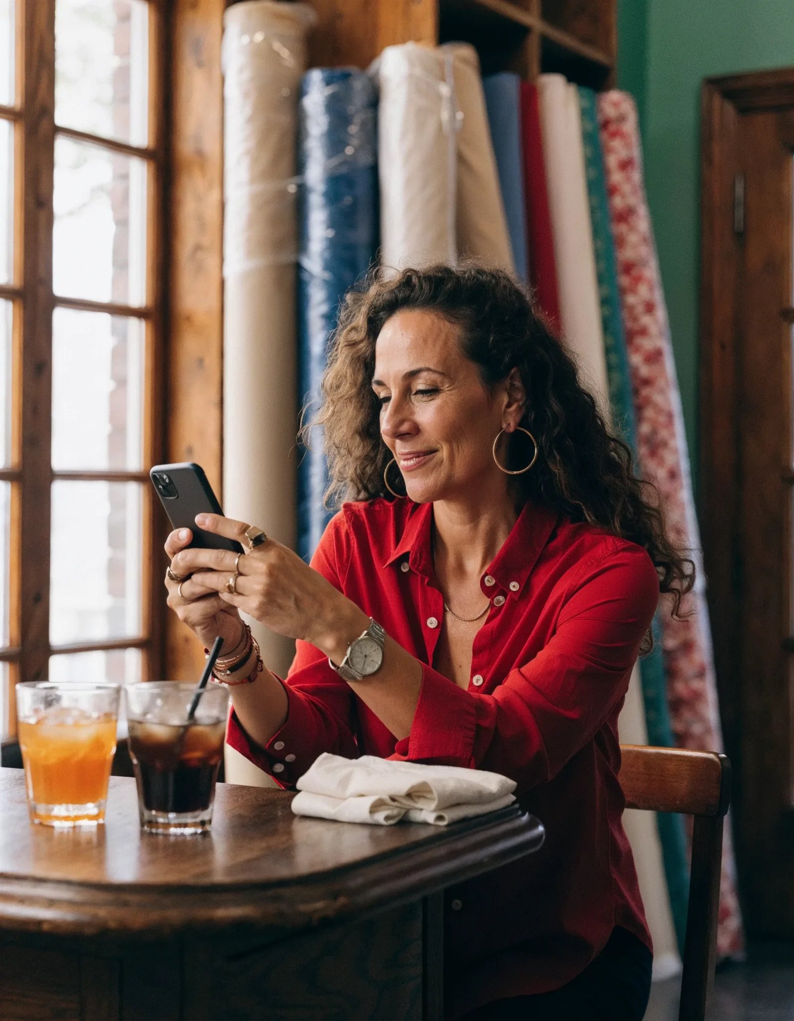 assunto de e-mail marketing: dona de boutique lendo e-mail no celular com sorriso