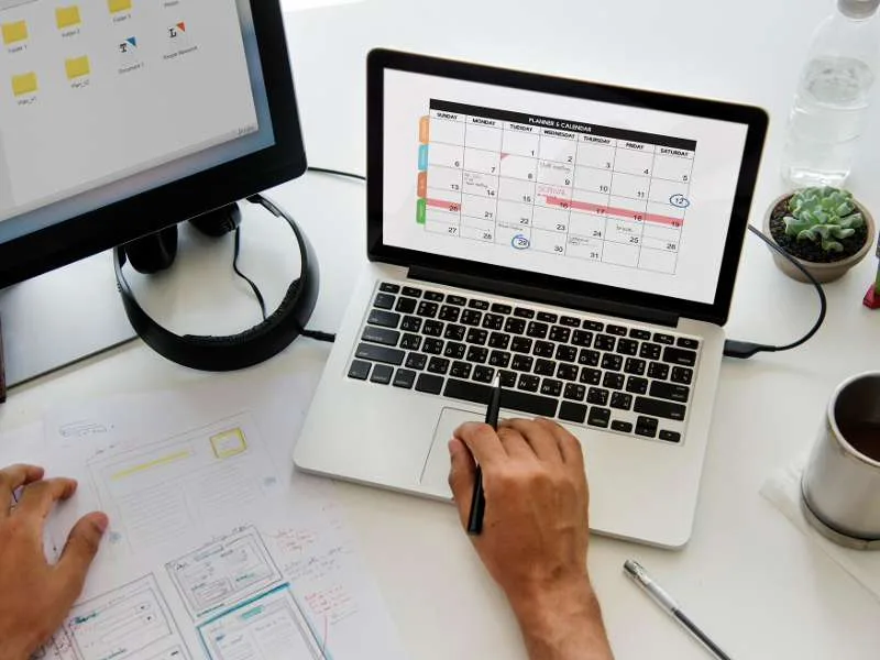 Calendário editorial para redes sociais: mão segurando smartphone com feed colorido em loja de roupas