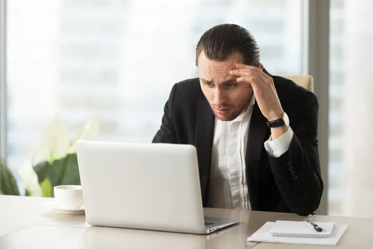 marketing digital é furada: empresário frustrado analisando resultados ruins no computador